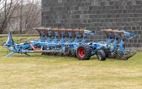 Potężny, niebieski pług 10 skibowy Lemken, gotowy do pracy na polu.