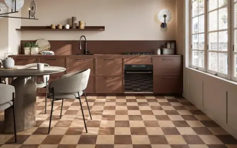 Cucina moderna con pavimento a scacchiera che crea una **tabella colori caldi**. Mobili marroni, tavolo rotondo e sedie grigie.