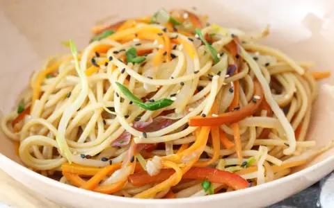 Chow mein en un tazón con verduras y semillas de sésamo.