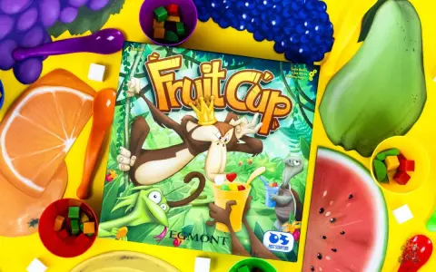 Gra Fruit Cup z owocami i kostkami. Małpa w koronie miesza owocowy deser.