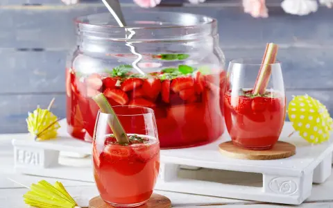 Erfrischende Rhabarber Bowle mit Erdbeeren und Minze, garniert mit Rhabarberstücken. Perfekt für den Sommer!