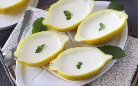 Fyra citroner fyllda med krämig dessert, garnerade med mynta. Perfekt för enklaste julbaket.