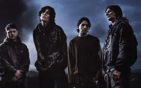 Członkowie Bring Me The Horizon stoją w mrocznej scenerii, z ognistymi płomieniami w tle.