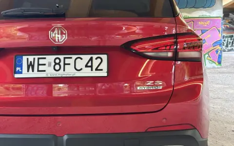 Czerwony tył samochodu MG ZS Hybrid z tablicą rejestracyjną WE 8FC42.