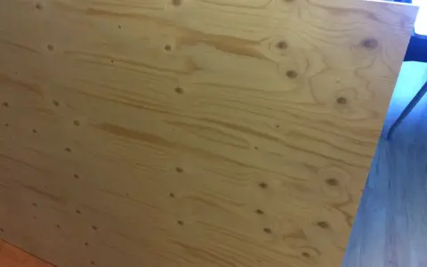 En stor skiva **betsa plywood** med tydliga ådringar och kvistar. Perfekt för ett rustikt projekt.