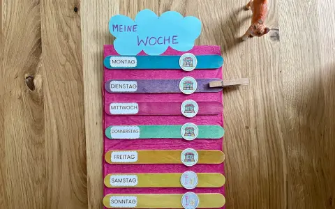 Montessori-Tafel zum Wochentage lernen. Bunte Holzstäbchen mit den Tagen der Woche und Symbolen.
