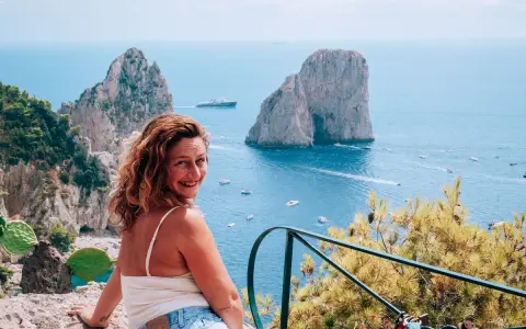 Donna sorridente con vista sui Faraglioni di Capri. Un ricordo indimenticabile da Castiglione.