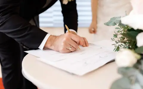 Novio firma documentos. Esto es parte de lo que se necesita para casarse por lo civil.