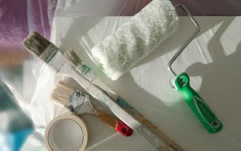 Pinceaux usagés et rouleau de peinture prêts à nettoyer après avoir utilisé du vernis.