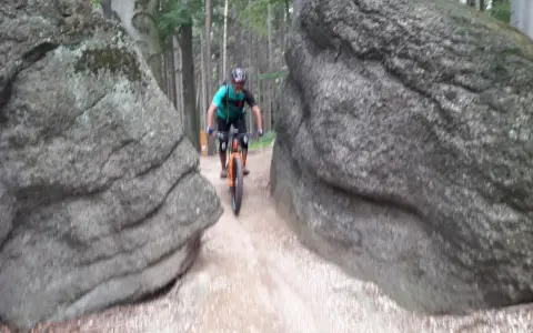 Rowerzysta pokonuje wąską ścieżkę między głazami na trasie w okolicach Lubania.