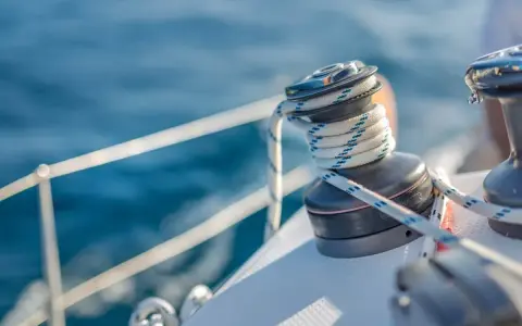 Un treuil de bateau avec une corde enroulée, un élément essentiel du vocabulaire de marin pour naviguer sur l'eau bleue.