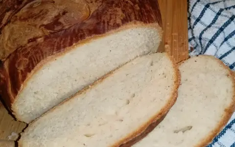 Puszysty chleb z mlekiem, pokrojony w kromki, z chrupiącą skórką. Idealny na śniadanie.