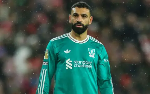 Mohamed Salah w zielonej koszulce Liverpoolu, symbol jego obecności w klubie, która jest kluczowa dla transferów Liverpool.
