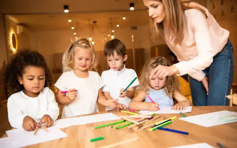 Nauczycielka wspiera dzieci w kreatywnym rysowaniu, promując edukację alternatywną.