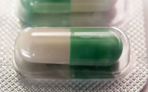 Dwie kapsułki leku Seronil 10 mg w blistrze. Jedna kapsułka jest biało-zielona, druga zielono-biała.