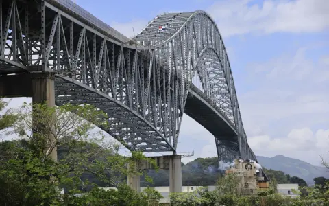 El **Puente de las Américas** cruza el Canal de Panamá, una imponente estructura de acero gris con un arco majestuoso.