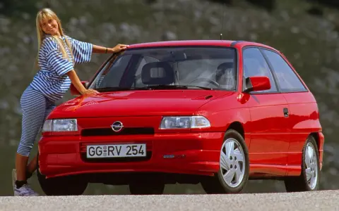 Mujer rubia posa junto a un coche histórico rojo. ¿Cuántos años tiene este coche?