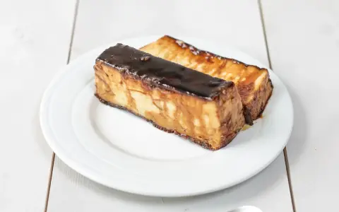 Dos porciones de pan de calatrava, un postre tradicional español, con una capa brillante de caramelo oscuro.