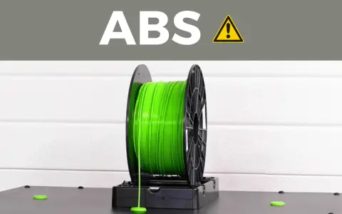 A spool of bright green ABS plastic filament, commonly used for 3D printing durable parts.