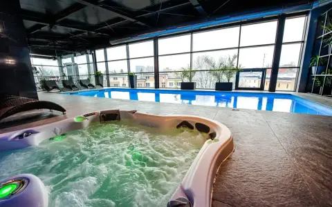 Relaks w hotelowym spa w Białymstoku: jacuzzi z bąbelkami i basen z widokiem na miasto.