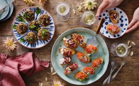 En härlig uppdukning med olika tapas recept. Små bruschettas med tomat, prosciutto och ost, samt fyllda champinjoner. Perfekt för en festlig stund!