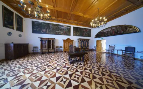 Wnętrze muzeum Gdańska - Ratusz Głównego Miasta. Bogato zdobiona sala z zabytkowymi meblami, obrazami i misterną parkietową posadzką.