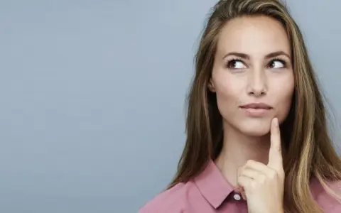 Nachdenkliche Frau mit langen Haaren, die über die Vorteile von Keratin und Kreatin für die Haargesundheit sinniert.