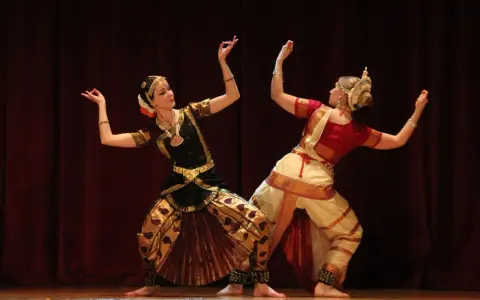 Anna Łopatowska i partnerka w tradycyjnych strojach tańczą taniec klasyczny Bharatanatyam.