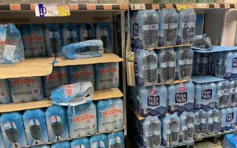 Scaffali pieni di bottiglie d'acqua in pacchi multipli. Il prezzo di 73 centesimi per una bottiglia d'acqua in crociera è un affare!