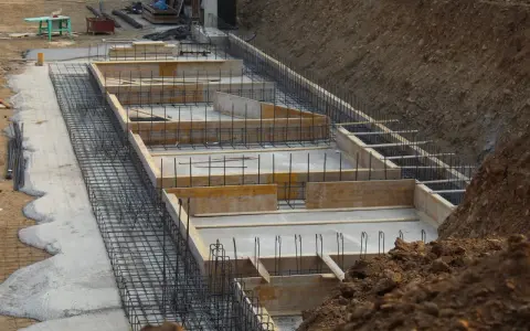 Szkielet zbrojeniowy i szalunki czekają na beton. Widać, ile bloczków na fundament potrzeba do budowy.