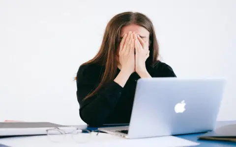 Donna disperata davanti al PC, vittima di un reato revenge porn.