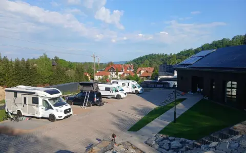 Kampery i samochody kempingowe zaparkowane na placu, gotowe na przygodę w Kudowie-Zdroju.