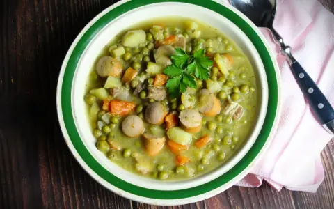Herzhaftes Erbsensuppe Rezept mit Würstchen, Kartoffeln und Karotten, garniert mit Petersilie. Ein Klassiker für kalte Tage.