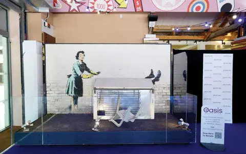 Banksy's "Girl with Balloon" installation, a prime example of art investment, displayed with a fridge and chair.