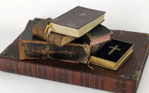 Stapel alter Bücher, einige mit Kreuzen auf dem Einband.