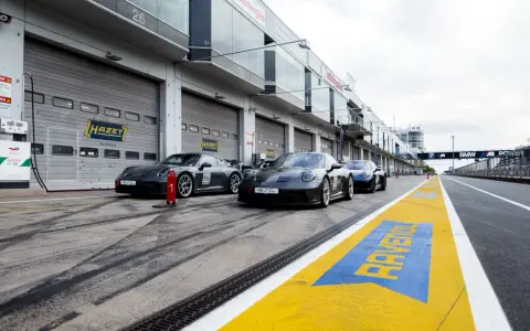 Porsche-Rennwagen in Boxengasse. Hier kann man pitstop teile selber mitbringen. Gelbe Markierungen auf dem Asphalt.