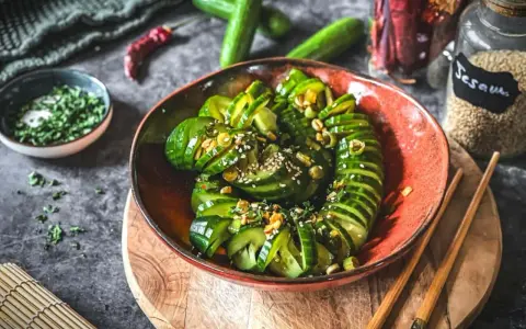 Ein erfrischender asiatischer Gurkensalat, garniert mit Sesam und Kräutern, bereit zum Genießen.