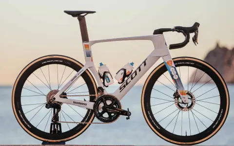 Biały rower szosowy Scott z kolorowymi akcentami, na jakich rowerach jeżdżą kolarze. Wyposażony w Dura-Ace, Shimano i Vittoria.