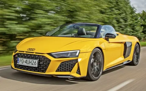 Żółty kabriolet Audi R8 pędzi po drodze. Sprawdź aktualną audi r8 cenę i poczuj moc!