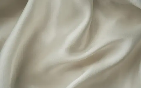 Miękka, kremowa satyna, która pięknie się układa, przypominając delikatny jedwab.