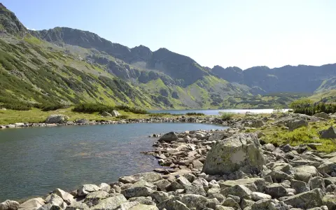 Kamieniste wybrzeże jeziora w Tatrach, idealne na wędrówkę szlakami turystycznymi Zakopane.