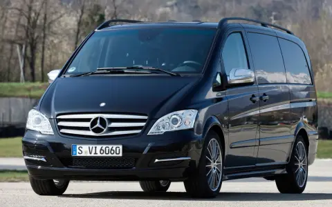 Czarny Mercedes Viano 3.0 V6 z przyciemnianymi szybami i relingami dachowymi, gotowy na podróż.