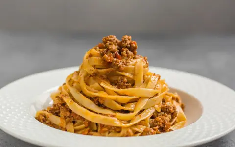 Porcja tagliatelle z bogatym sosem mięsnym, klasyczne spaghetti bolognese w nowej odsłonie.