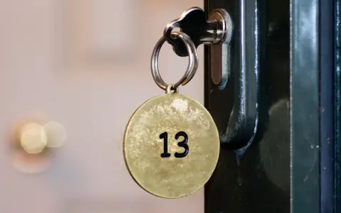 Klucz z okrągłą zawieszką z numerem 13 włożony do zamka.