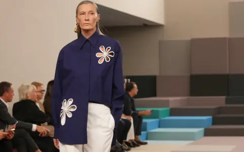 Modella con camicia blu Fendi e pantaloni bianchi, un'icona di stile che racconta la sua storia.