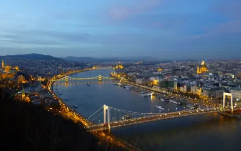 Vista nocturna de Budapest con el río Danubio y sus puentes iluminados, creando un paisaje urbano mágico.