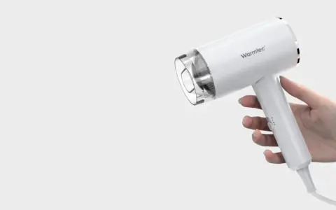 Biała suszarka Warmtec trzymana w dłoni.