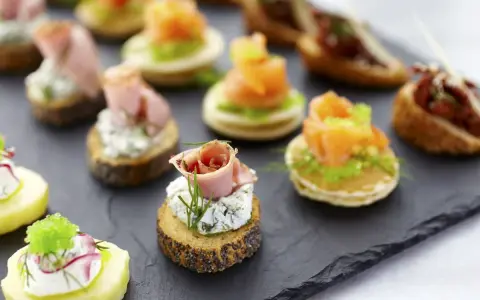 Deliciosos entrantes navideños: canapés variados con salmón, jamón, queso y patata. ¡Perfectos para celebrar!