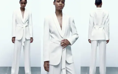 Mujer posa con un elegante traje blanco de pantalón y blazer con cinturón. Un look sofisticado para combinar traje blanco mujer.