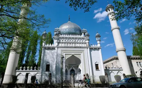 Weiße Moschee mit Kuppel und Minaretten, ein Beispiel für orientalische Architektur, im Sonnenschein.